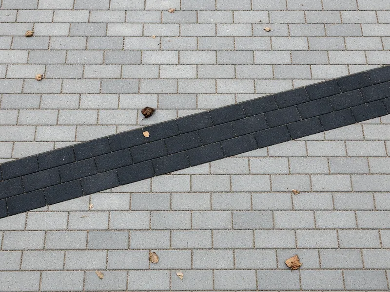 Graue Pflastersteine mit einem diagonalen schwarzen Band