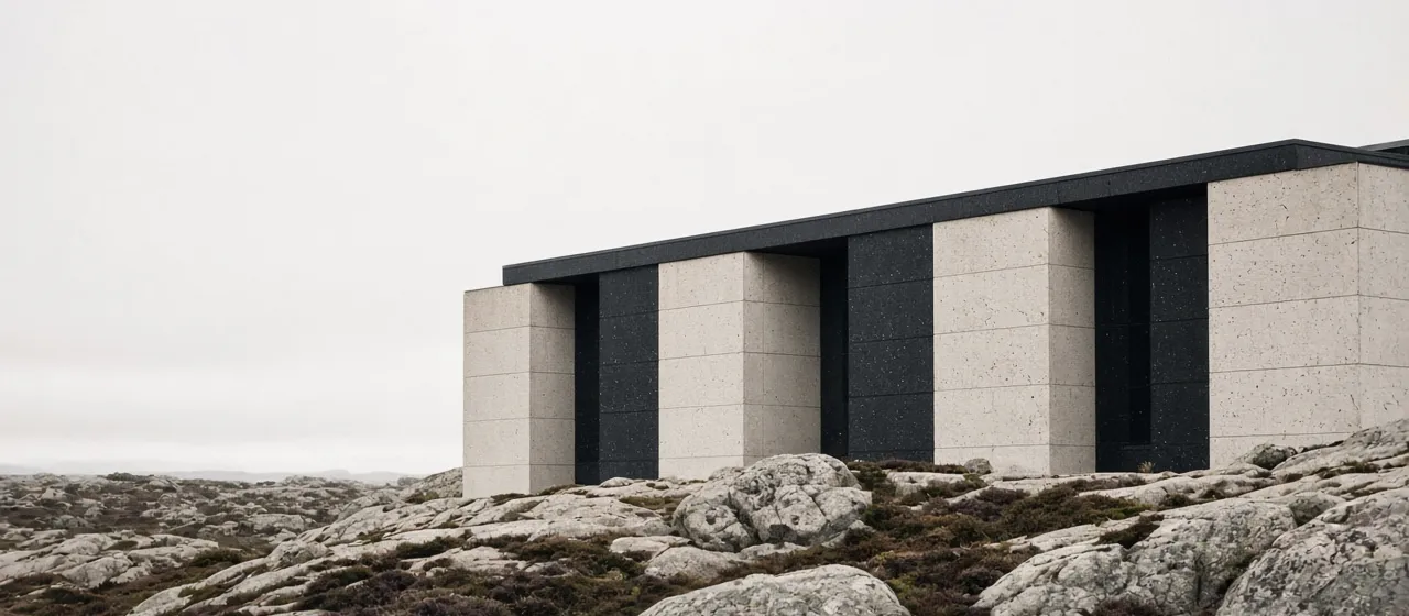 Nordisk bygg med lyse og svarte betongpaneler på bergknauser